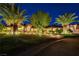 Night view of single-story home with palm trees, lights, and a paved driveway at 8275 W Craig Rd, Las Vegas, NV 89129