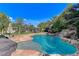 Inviting pool with a waterfall, lush landscaping, and putting green at 8275 W Craig Rd, Las Vegas, NV 89129