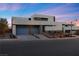 Modern, two-story home with sleek design, multiple garage doors, and landscaping at 32 Rainbow Point Pl, Henderson, NV 89011