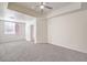 Main bedroom with neutral walls and carpet, a ceiling fan, and large window at 43 E Agate Ave # 204, Las Vegas, NV 89123