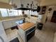 Kitchen with white cabinets, an island with butcher block countertop, and hanging pots and pans at 611 E Fairway Rd, Henderson, NV 89015