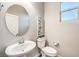 Small bathroom with pedestal sink, toilet, and oval mirror at 642 Angel Aura St, Las Vegas, NV 89138