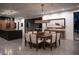 Modern dining room with a large wooden table and contemporary light fixture at 6876 Milos Rd, Las Vegas, NV 89118