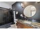 Modern bathroom with dark tile, granite countertop, and a large mirror at 20 Lassen St, Blue Diamond, NV 89004