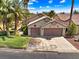 Single story home with two car garage, palm trees and green lawn at 1131 Golf Club, Laughlin, NV 89029