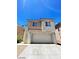 Two-story house with a beige exterior and a two-car garage at 5213 Castle Butte Ct, North Las Vegas, NV 89031