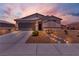 One story house with gray garage door and landscaped yard at sunset at 3558 E Malheur Ave, Pahrump, NV 89061