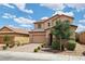 Inviting two-story home with a tile roof, brick driveway, and desert landscaping at 2130 Danzinger Pl, Henderson, NV 89044