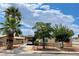 Tan house with palm trees and a chain link fence at 517 Miller Ave, North Las Vegas, NV 89030