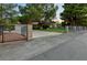 Brick house with a gated driveway and a well-manicured lawn at 8245 Helena Ave, Las Vegas, NV 89129