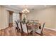 Bright dining room featuring hardwood floors, chandelier, and seating for eight at 4156 Balmoral Castle Ct, Las Vegas, NV 89141