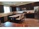 Spacious kitchen with dark brown cabinetry, granite island, and stainless steel appliances at 830 Earth Luster Rd, Las Vegas, NV 89178