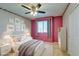 A bedroom with pink accent wall, ceiling fan, bed, rug, nightstands, and artwork at 6630 Evander St, North Las Vegas, NV 89086