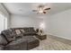 Spacious living room featuring a large sectional sofa and ceiling fan at 8351 Gold River Ct, Las Vegas, NV 89113