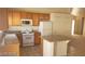 Kitchen boasts wood cabinets, granite countertops, and white appliances at 336 River Glider Ave, North Las Vegas, NV 89084