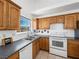 Kitchen with oak cabinets, white appliances and a large window at 2441 Ottawa St, Sandy Valley, NV 89019