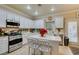 Well-lit kitchen boasting white cabinets, stainless steel appliances, and a center island at 519 Cypress Links Ave, Henderson, NV 89012