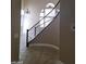 Curved staircase with wrought iron railing and chandelier in the entryway at 9758 Camino Capistrano Ln, Las Vegas, NV 89147