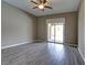 Bright bedroom with wood-look tile floors and sliding glass door to patio at 1140 Apollo Gardens St, Henderson, NV 89052