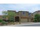 Two-story house with stone accents, a three-car garage, and landscaping at 1140 Apollo Gardens St, Henderson, NV 89052