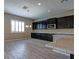 Modern kitchen with dark cabinetry, granite counters, and tile floors at 1140 Apollo Gardens St, Henderson, NV 89052