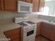 Kitchen with light wood cabinets and white appliances at 1023 Sunny Acres Ave, North Las Vegas, NV 89081