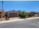 Tan two-story house with a three-car garage, landscaping, and palm trees at 936 Via Vannucci Way, Henderson, NV 89011