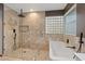 Spa-like bathroom with walk-in shower, soaking tub, and stylish tile at 390 E Delamar Dr, Henderson, NV 89015