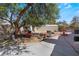 Large backyard with mature trees, storage shed, and a fountain at 6356 Canyon Ridge Dr, Las Vegas, NV 89108