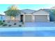 Two-story house with three car garage and neutral colors at 6483 Dove Point Pl, Las Vegas, NV 89130