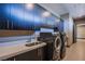 Modern laundry room with dark cabinetry, stainless steel sink, and washer/dryer at 11166 Villa Bellagio Dr, Las Vegas, NV 89141