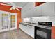 Kitchen with white cabinets, black appliances, and orange walls at 5290 Obannon Dr, Las Vegas, NV 89146