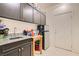 Well-equipped laundry room with dark cabinets, sink, and extra storage at 10302 Artful Stone Ave, Las Vegas, NV 89149