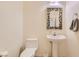 Clean and bright bathroom with pedestal sink and mosaic mirror at 10302 Artful Stone Ave, Las Vegas, NV 89149