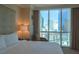 Bedroom with city view, king-size bed, and armchair at 145 E Harmon Ave # 1121, Las Vegas, NV 89109