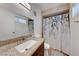 Bright bathroom featuring a single sink vanity with a shower and tub at 7244 Bridgeview Ave, Las Vegas, NV 89147