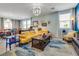 Living room with yellow sectional sofa, coffee table, and large windows at 2558 Blossom Ave, Pahrump, NV 89048