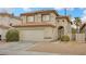 Two-story house with a beige exterior and a two-car garage at 5051 Jacarilla Ln, North Las Vegas, NV 89031