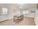 Bright dining room with glass table, wood-look flooring, and access to kitchen at 6771 Shelter Ln, Las Vegas, NV 89103