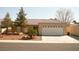 Tan house with tile roof, two-car garage, and landscaping at 4224 Falcon Hill St, North Las Vegas, NV 89032