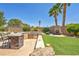 Landscaped backyard with a built-in BBQ and fireplace at 3130 Appleblossom Cir, Las Vegas, NV 89117