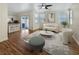 Virtually staged living room with light flooring, white couch, and kitchen view at 8473 Bellery Ave, Las Vegas, NV 89143