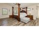 Large main bedroom with four-poster bed, wood floors, and windows at 6391 Tempting Choice Ave, Las Vegas, NV 89131