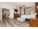 Large main bedroom with wood-like flooring, ornate bedframe and columns, and ceiling fan at 6391 Tempting Choice Ave, Las Vegas, NV 89131