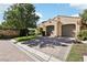 Two-car garage with paver driveway and mature trees in front at 11783 Weybrook Park Dr, Las Vegas, NV 89141