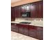 Dark wood kitchen cabinets, gas cooktop and light countertops at 2873 Knoxville Ct, Henderson, NV 89052