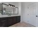 Bathroom with dark vanity, large mirror, and quartz countertop at 6004 Chessington Ave, Las Vegas, NV 89131