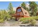 A-frame cabin nestled in a mountain setting with a deck and garage at 2196 Via Dulcedo St, Mount Charleston, NV 89124