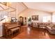 Living room with hardwood floors, sectional sofa, and large windows at 1834 Escondido Ter, Henderson, NV 89074