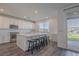 Modern kitchen island with white cabinets, quartz countertops, and four barstools at 175 Strada Fontana, Henderson, NV 89011